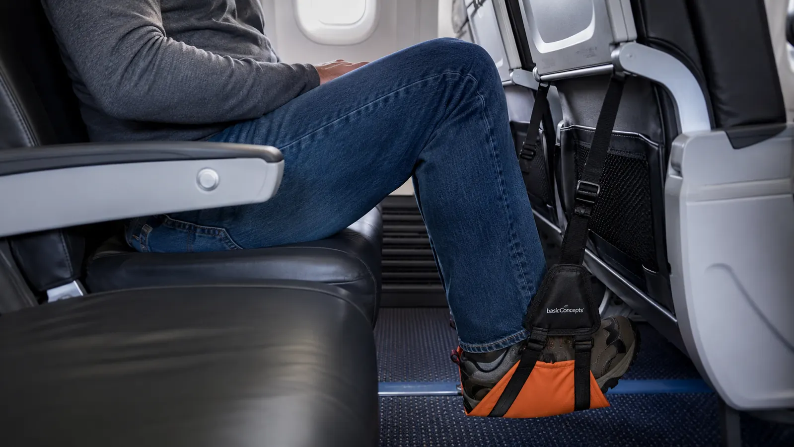 Measuring tape showing the gap between a tall passenger's knee and the seatback with the foot hammock lowered