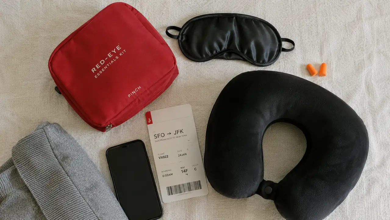 Overhead shot of a carry-on packing cube with an eye mask, earplugs, and travel pillow tucked inside