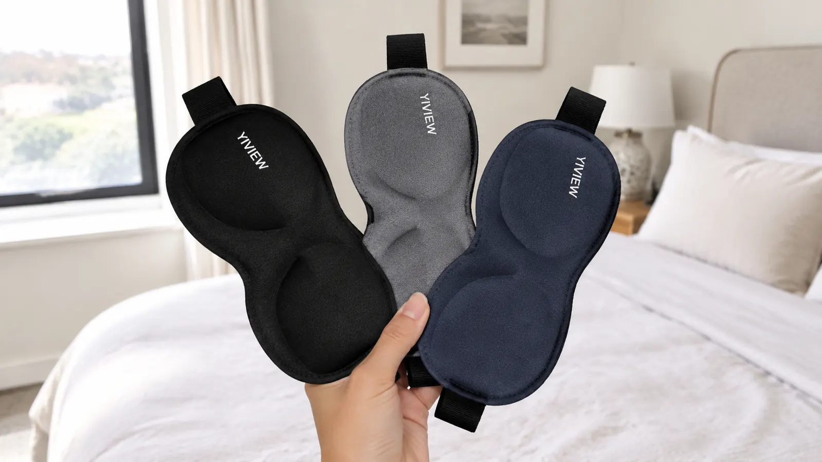 Hand holding all three colors of the YIVIEW sleep mask pack fanned out